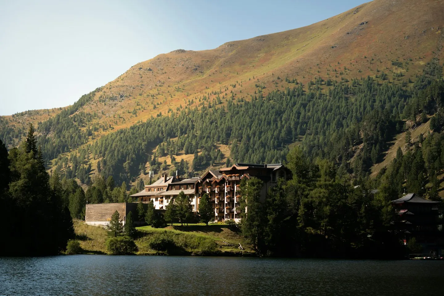 Lakeside lodge beneath wooded mountains