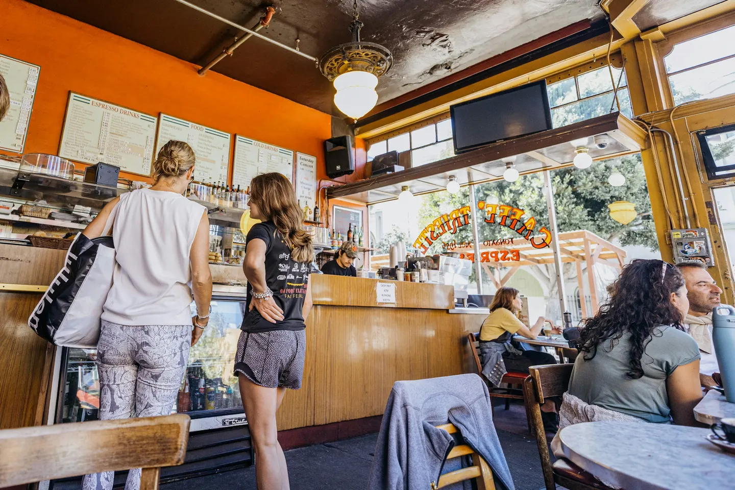 Customers at the counter and tables of a busy café