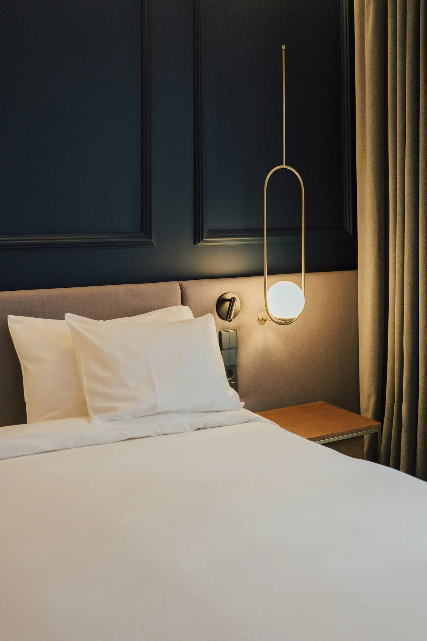 Bed with white sheets and pillows in a quiet room