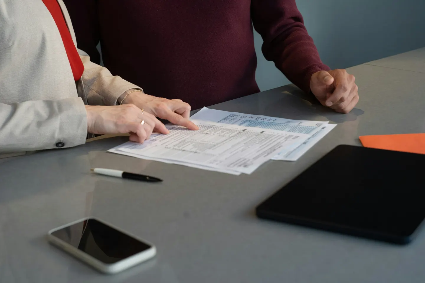 Two people reviewing financial documents at a meeting table